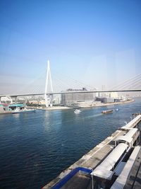 View of bridge over sea against clear blue sky