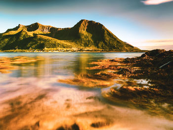 Scenic view of sea and mountains against sky