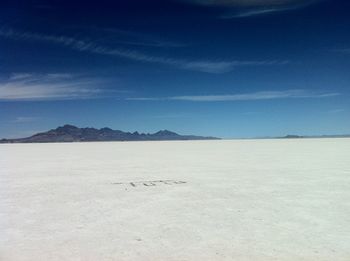 Scenic view of desert against blue sky