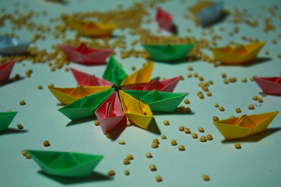 High angle view of colorful paper boats with beans on table