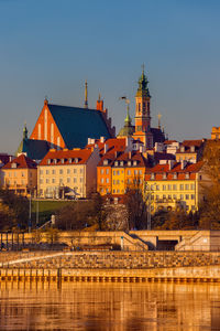 Buildings in city against clear blue sky