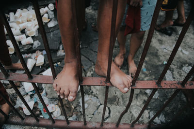 Low section of boy standing on fence