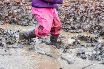 Low section of person walking in mud