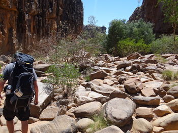 Rear view of man walking on rocks