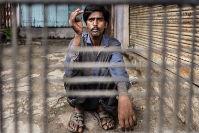 Portrait of young man standing against wall