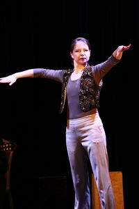 Woman with arms outstretched against black background