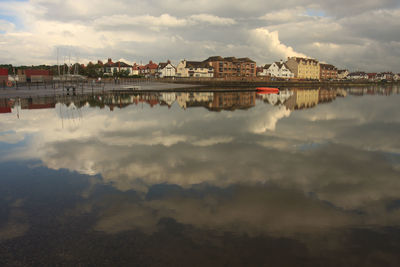 Reflection of clouds in town against sky