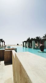 View of swimming pool by sea against clear sky