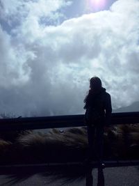 Silhouette of woman against cloudy sky