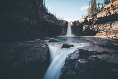 Scenic view of waterfall against sky