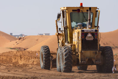 View of tractor in desert against clear sky