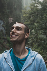 Portrait of young man looking away in forest