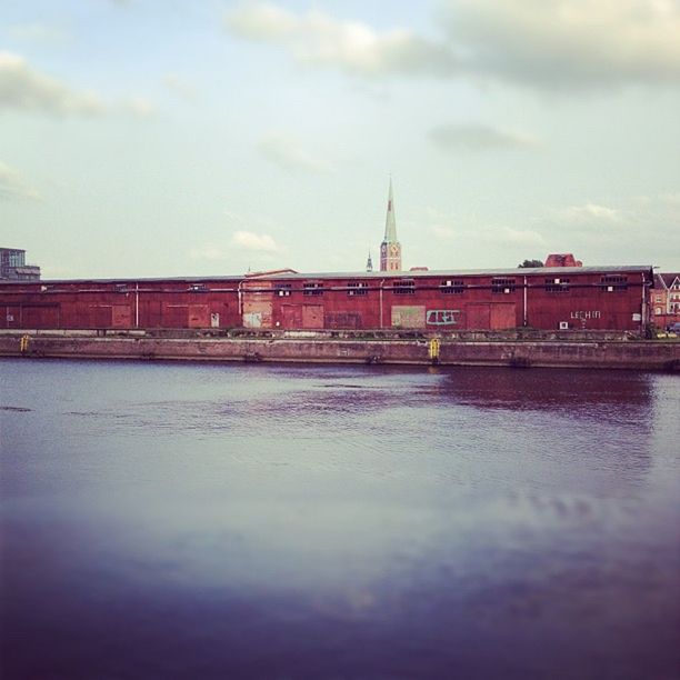 architecture, built structure, building exterior, water, sky, waterfront, cloud - sky, city, surface level, river, reflection, dusk, sea, cloud, travel destinations, outdoors, cloudy, mid distance, rippled, no people