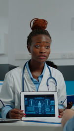 Portrait of young woman using laptop at clinic