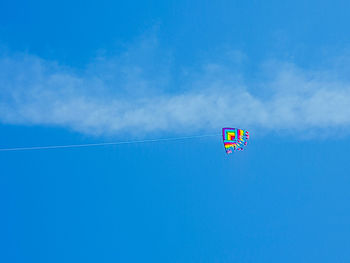 Low angle view of kite flying against blue sky