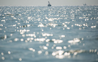 Flock of birds in sea against sky