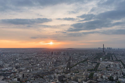 Aerial view of cityscape against cloudy sky