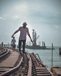 People standing on shore against sky