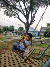 Portrait of boy playing on swing