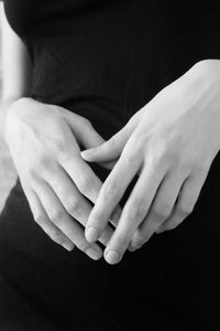 Midsection of woman with hands clasped