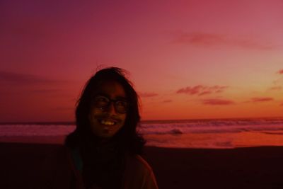 Portrait of beautiful woman on beach against sky during sunset