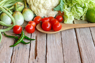 Tomatoes and vegetables on wood