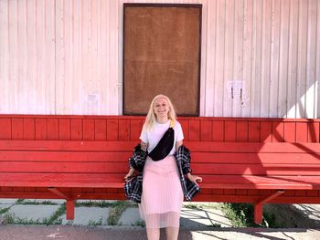 Portrait of woman standing against wall