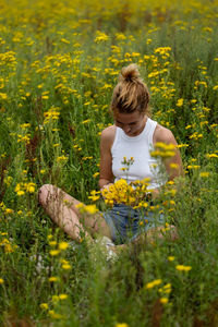 Rear view of woman sitting on field