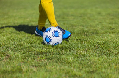 Low section of person playing soccer on field