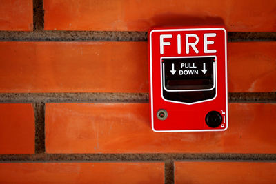 Close-up of fire alarm on brick wall
