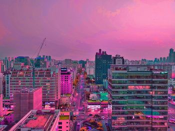 Illuminated buildings against sky during sunset