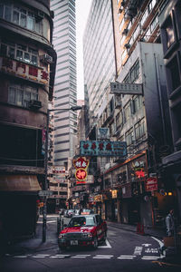 Cars on city street by buildings