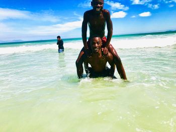 Men on beach against sky