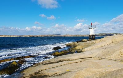 Lighthouse on beach against sky