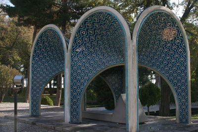 Metallic structure in park against buildings