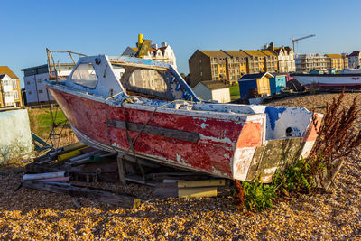 Abandoned boats moored on shore against sky