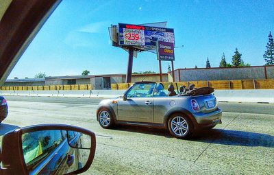 Cars on road against blue sky