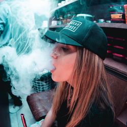 Portrait of young woman smoking outdoors