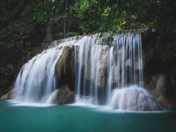 Scenic paradise waterfall with turquoise pond in rainforest. erawan falls, kanchanaburi, thailand.