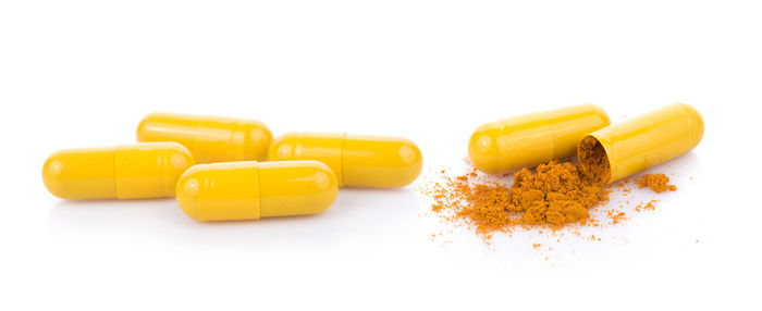 Panoramic view of yellow capsules over white background