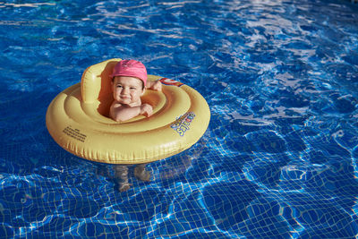 High angle portrait of smiling boy in swimming pool