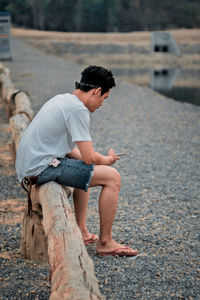 Side view of boy sitting outdoors