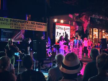 Group of people at music concert in city at night