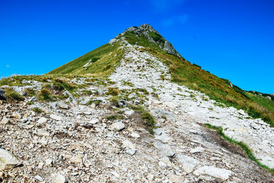 Low angle view of mountain against clear blue sky