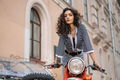 Portrait of young woman standing in city