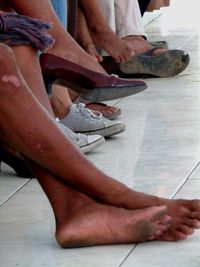 Low section of woman sitting on tiled floor