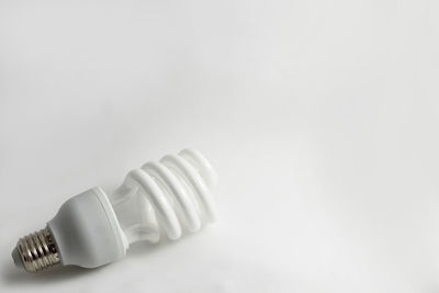 Close-up of light bulb over white background