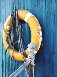 Close-up of life belt hanging on wooden wall