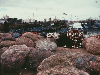 Boats moored on sea against cloudy sky