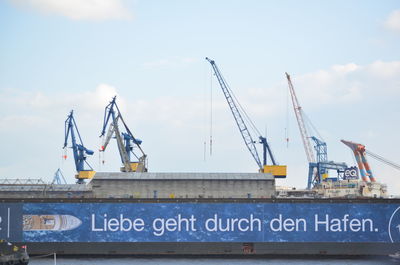 Information sign at harbor against sky